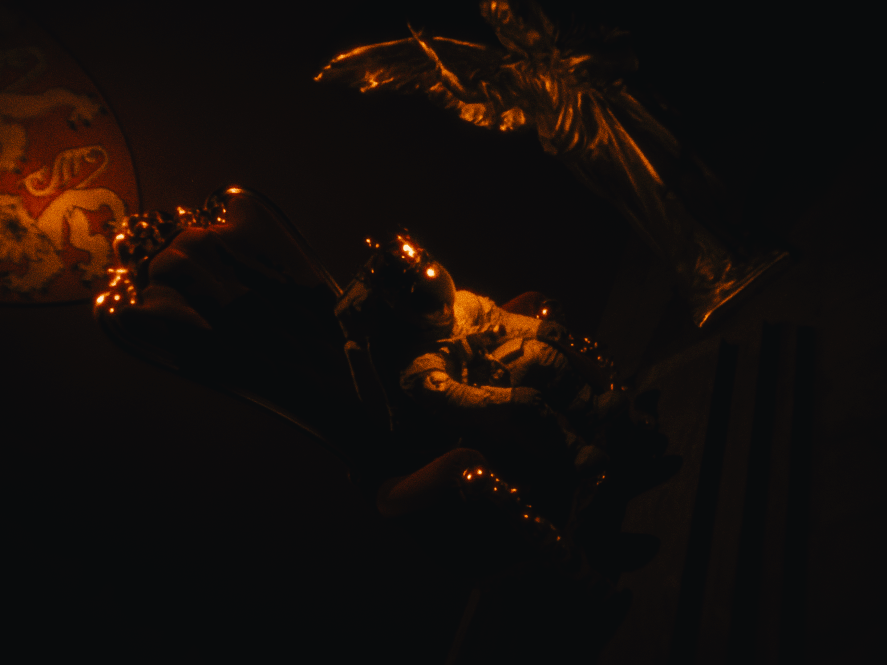 Miss A7L in a crown on a throne with chiaroscuro style lighting.